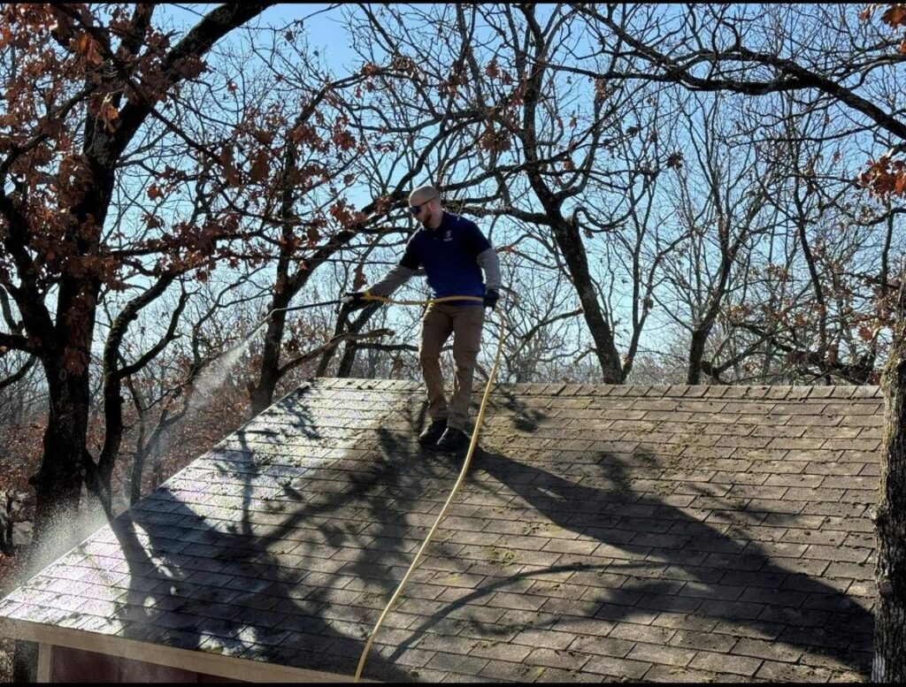 KJ Power Washing technician soft washing a residential roof